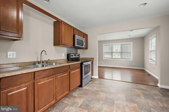 a kitchen with stainless steel appliances granite countertop a sink stove and cabinets