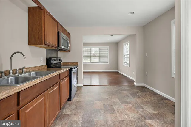 a kitchen with stainless steel appliances granite countertop a stove a sink and a microwave