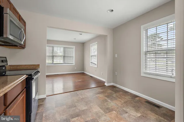 a view of a kitchen and an empty room and window