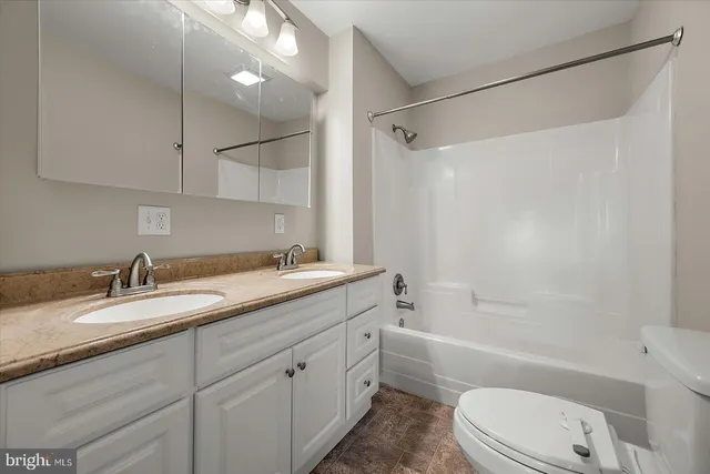 a bathroom with a granite countertop sink toilet tub and shower