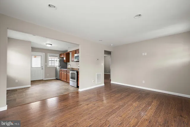 a view of a kitchen with wooden floor and electronic appliances