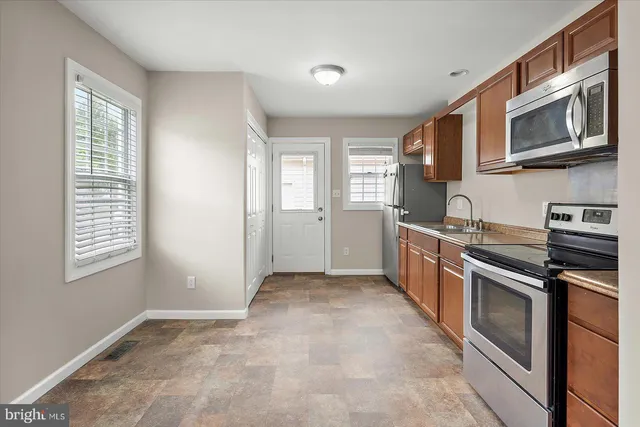 a kitchen with stainless steel appliances granite countertop a stove a sink and a microwave