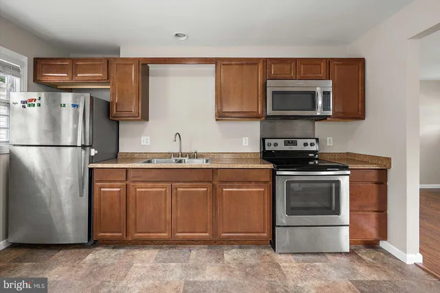 a kitchen with stainless steel appliances granite countertop a refrigerator stove and microwave