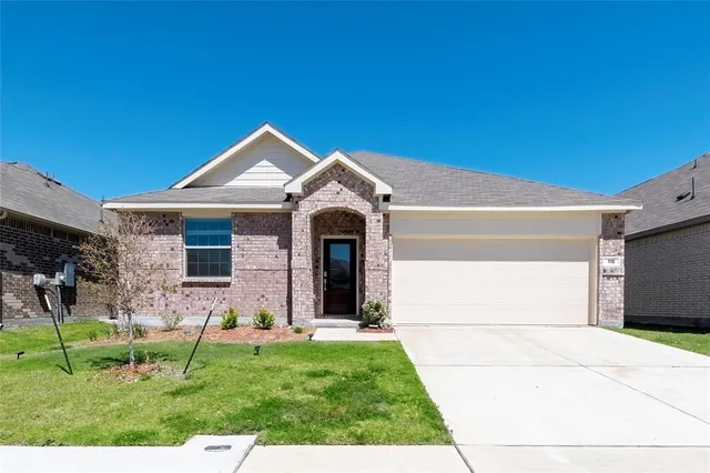 a front view of a house with a yard and green space
