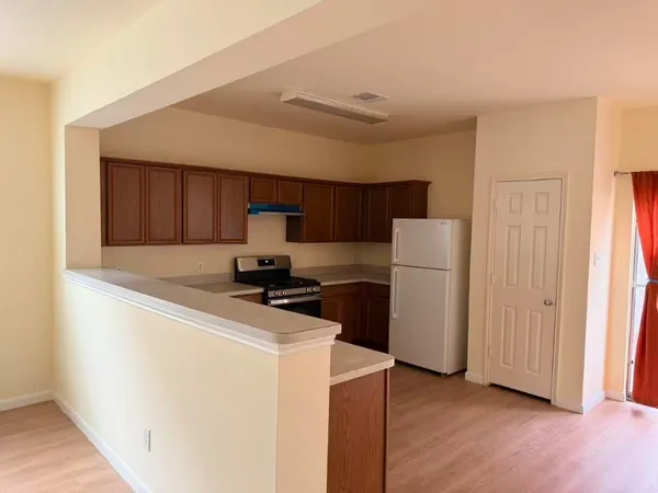 a kitchen with stainless steel appliances granite countertop a refrigerator a stove and a wooden floors