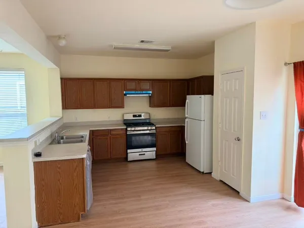 a kitchen with stainless steel appliances granite countertop a stove a sink and a refrigerator