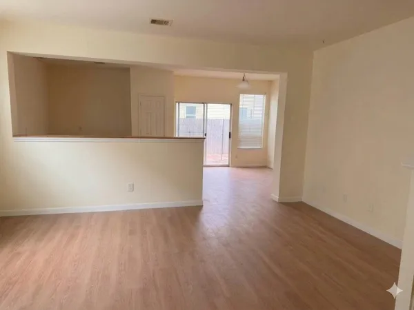 a view of a kitchen with furniture and wooden floor