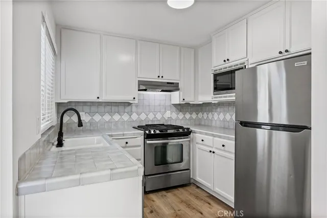 a kitchen with a stove sink and refrigerator