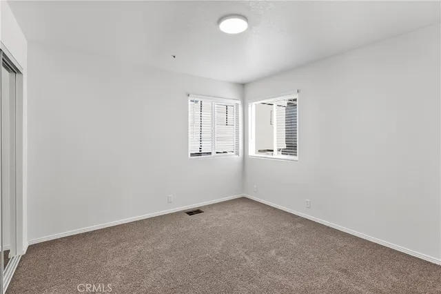 an empty room with windows and closet