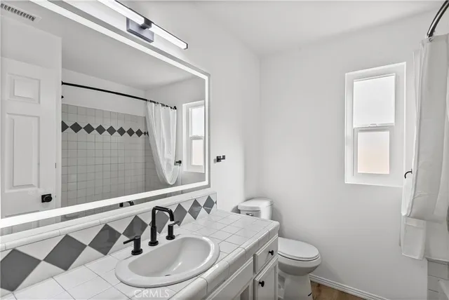 a bathroom with a sink a toilet and a mirror