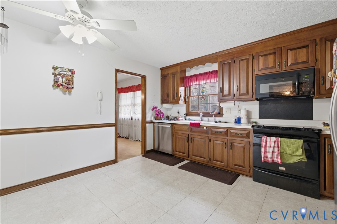 12508 Percival Street Chester, VA 23831 - Photo 13 of 30 a kitchen with stainless steel appliances granite countertop a stove top oven a sink a microwave and a refrigerator