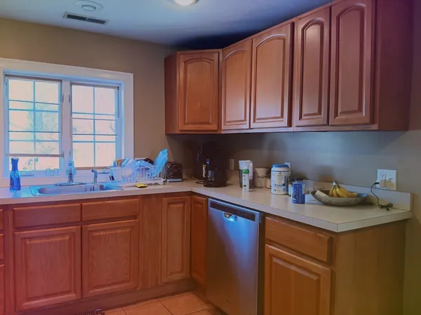 a kitchen with stainless steel appliances granite countertop a sink dishwasher stove and cabinets with wooden floor
