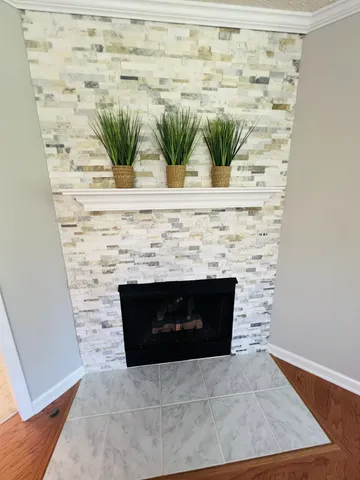 a living room with a fireplace and a potted plant