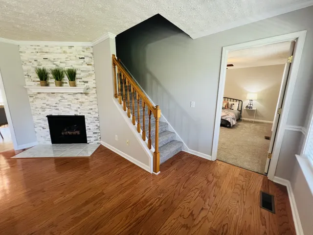 a view of a hallway with wooden floor and staircase