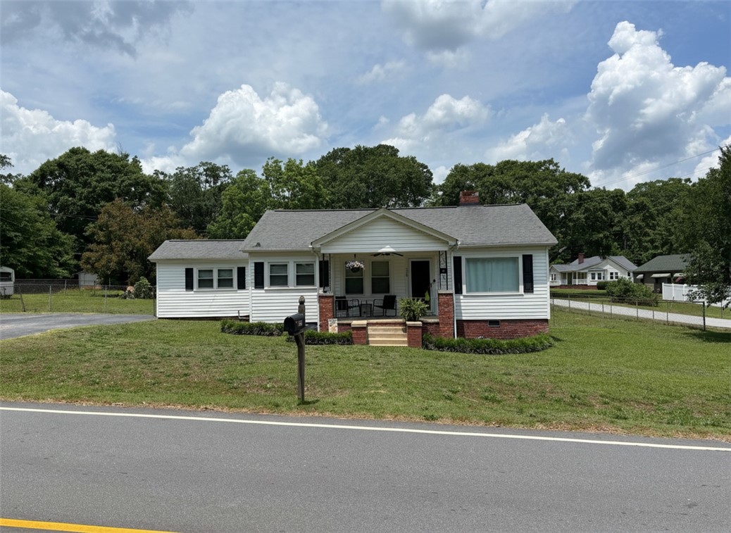 710 O Neal Street Belton, SC 29627 - Photo 1 of 18 A charming bungalow with a welcoming covered front porch and neat landscaping, nestled against a backdrop of mature trees.