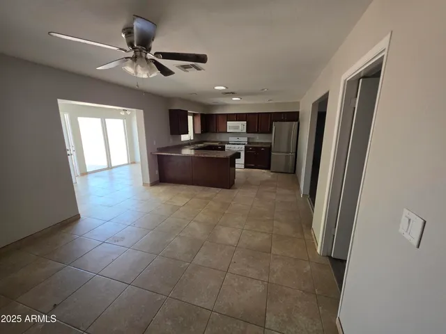 a living room with stainless steel appliances furniture and a kitchen view