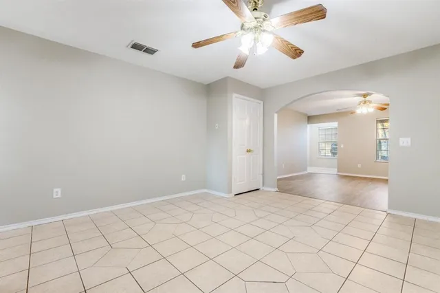 a view of an empty room and chandelier fan
