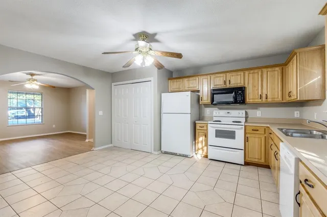 a kitchen with cabinets stainless steel appliances and a window