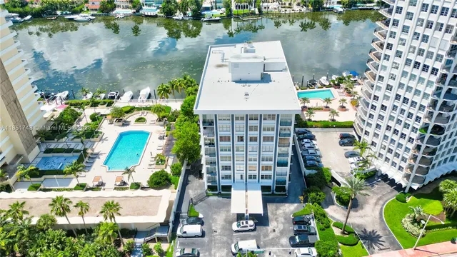 an aerial view of residential houses with outdoor space and lake view