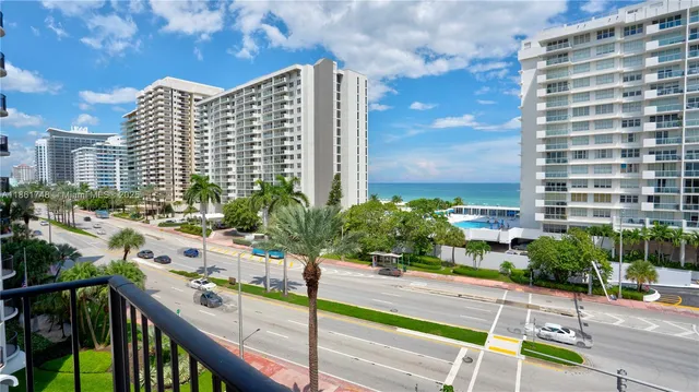a view of a balcony with a couple of cars parked in parking lot