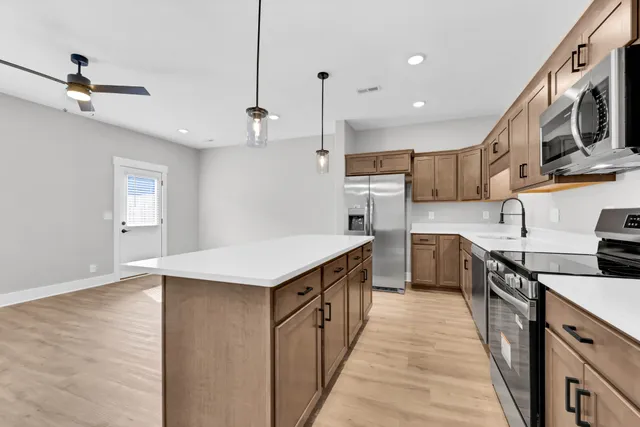 a kitchen with stainless steel appliances granite countertop a sink a stove and a refrigerator