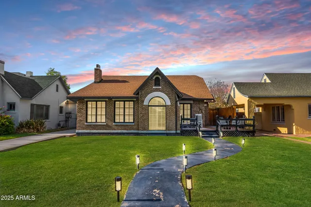 a view of a big house with a big yard and large trees