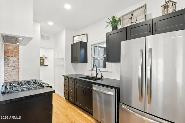a bedroom with a bed a flat screen tv and a dresser