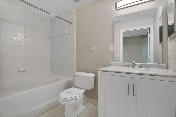 a bathroom with a granite countertop sink a toilet and shower
