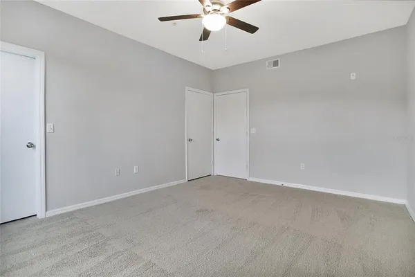 an empty room with chandelier fan