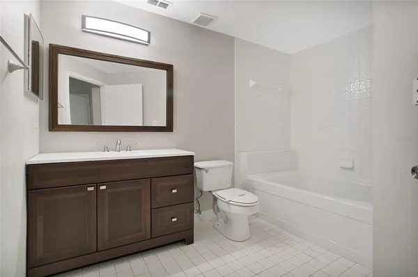 a bathroom with a toilet a sink a mirror and bathtub
