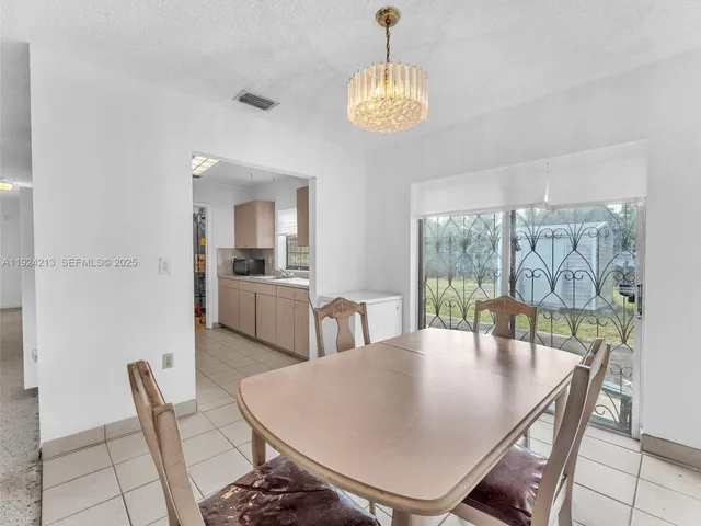 a view of a dining room with furniture and chandelier