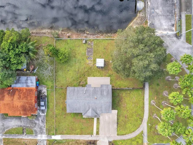 an aerial view of a house with a yard basket ball court and outdoor seating