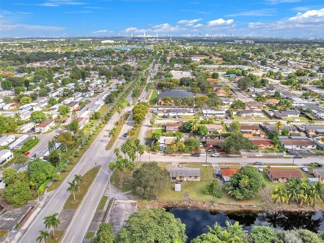 an aerial view of residential houses with outdoor space and trees