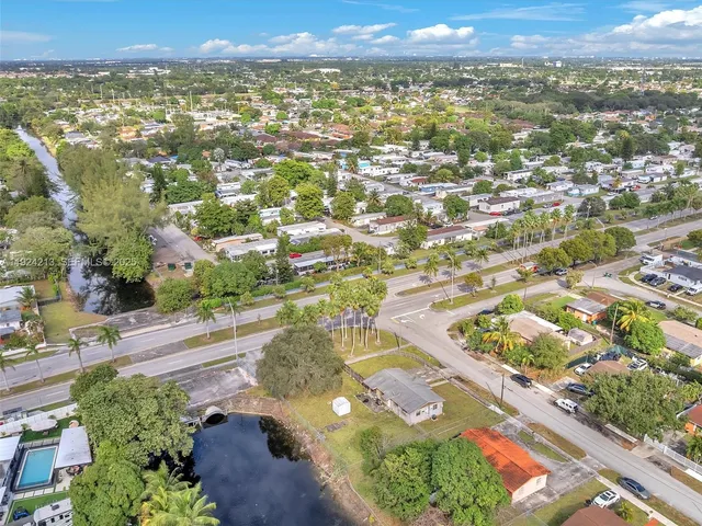 an aerial view of residential houses with outdoor space and trees