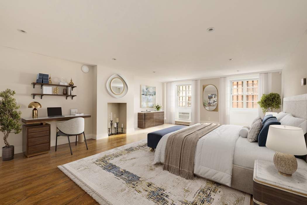 243 East 17th Street Manhattan, NY 10003 - Photo 32 of 44 a spacious bedroom with a bed a table and chair