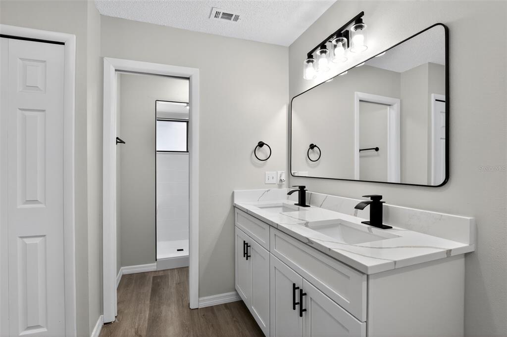 3441 Calgary Lane Mount Dora, FL 32757 - Photo 13 of 20 a bathroom with a double vanity sink and a mirror