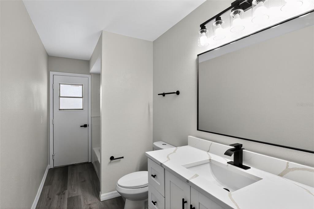 3441 Calgary Lane Mount Dora, FL 32757 - Photo 14 of 20 a bathroom with a toilet sink a mirror and vanity