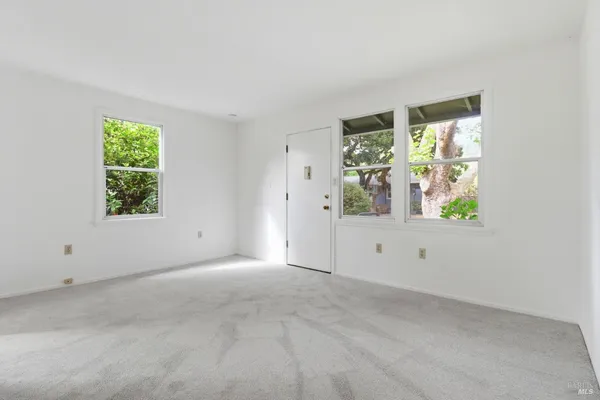 an empty room with windows and closet