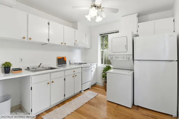 a kitchen with white cabinets and white appliances