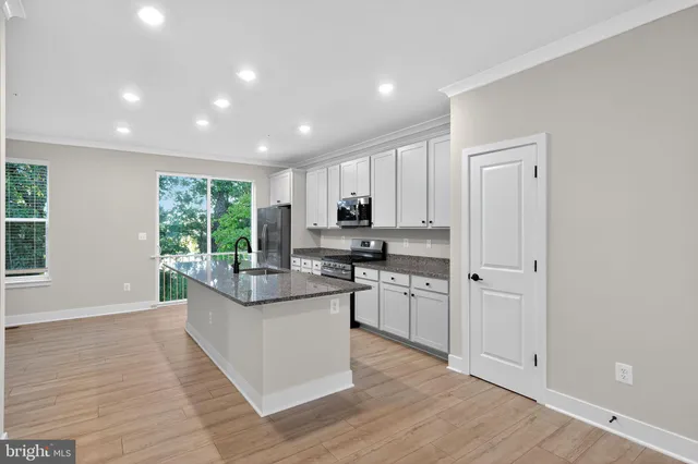 a kitchen with counter top space and wooden floor