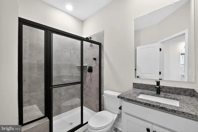 a bathroom with a granite countertop sink toilet and shower