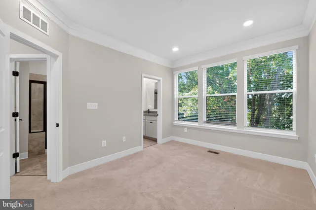 an empty room with large windows and a livingroom