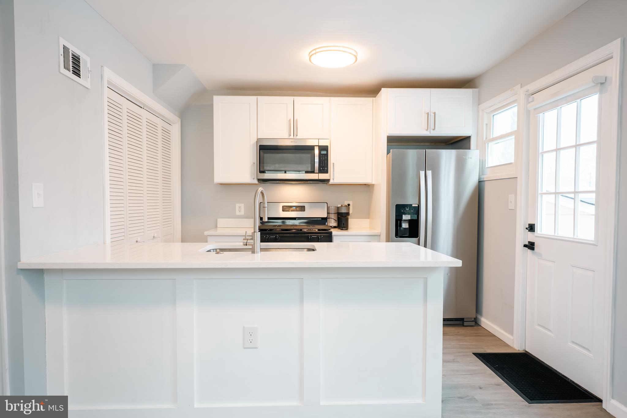 3410 Embry Street Silver Spring, MD 20902 - Photo 7 of 28 a kitchen with a refrigerator a stove a sink and a window