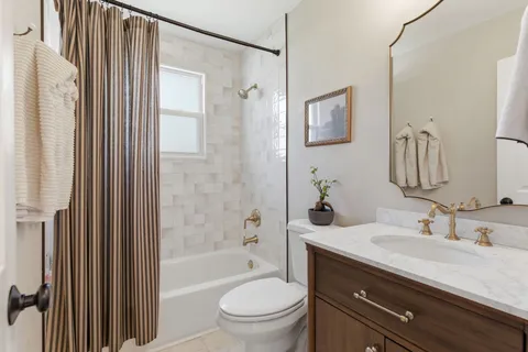 a bathroom with a granite countertop sink a toilet a mirror a vanity and shower