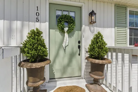 a view of a porch with chairs and potted plants