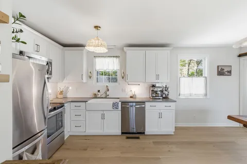 a kitchen with stainless steel appliances a stove a sink and a refrigerator