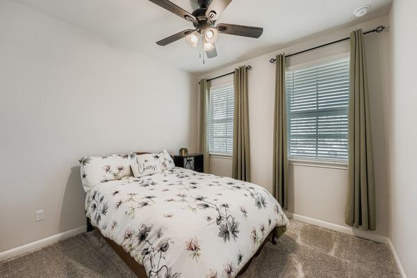 148 Gullivers Drive Elgin, TX 78621 - Photo 14 of 21 Carpeted bedroom featuring baseboards and a ceiling fan