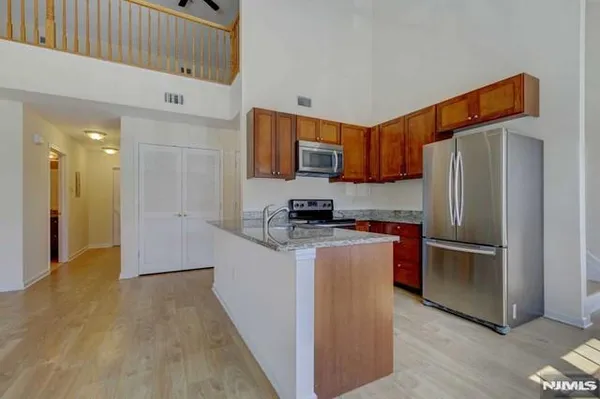 a kitchen with stainless steel appliances granite countertop a refrigerator and a stove