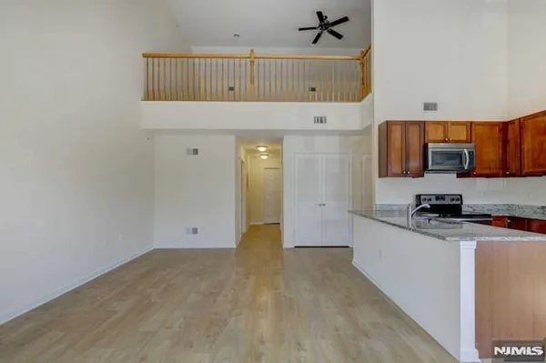 a kitchen with granite countertop a stove a sink and a refrigerator