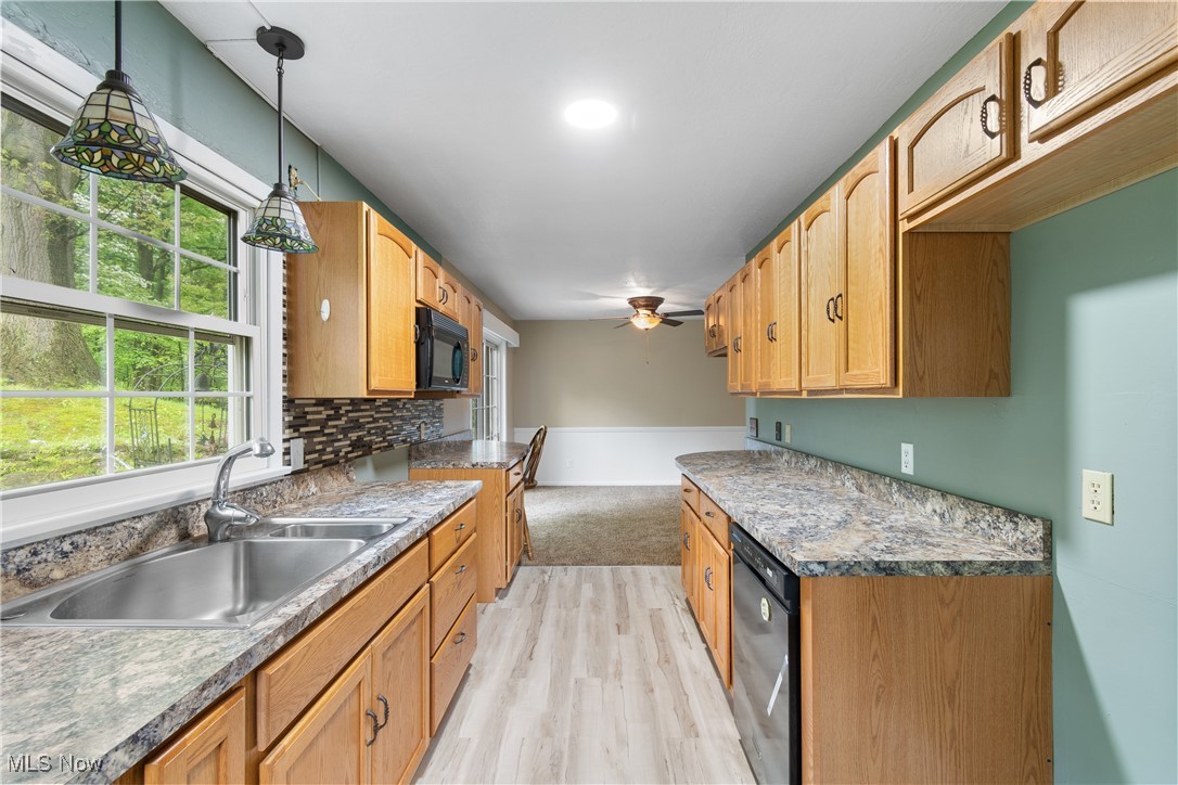 3143 Ethan Allen Road Barberton, OH 44203 - Photo 14 of 37 Kitchen with light wood-style flooring, black appliances, plenty of natural light, and a ceiling fan